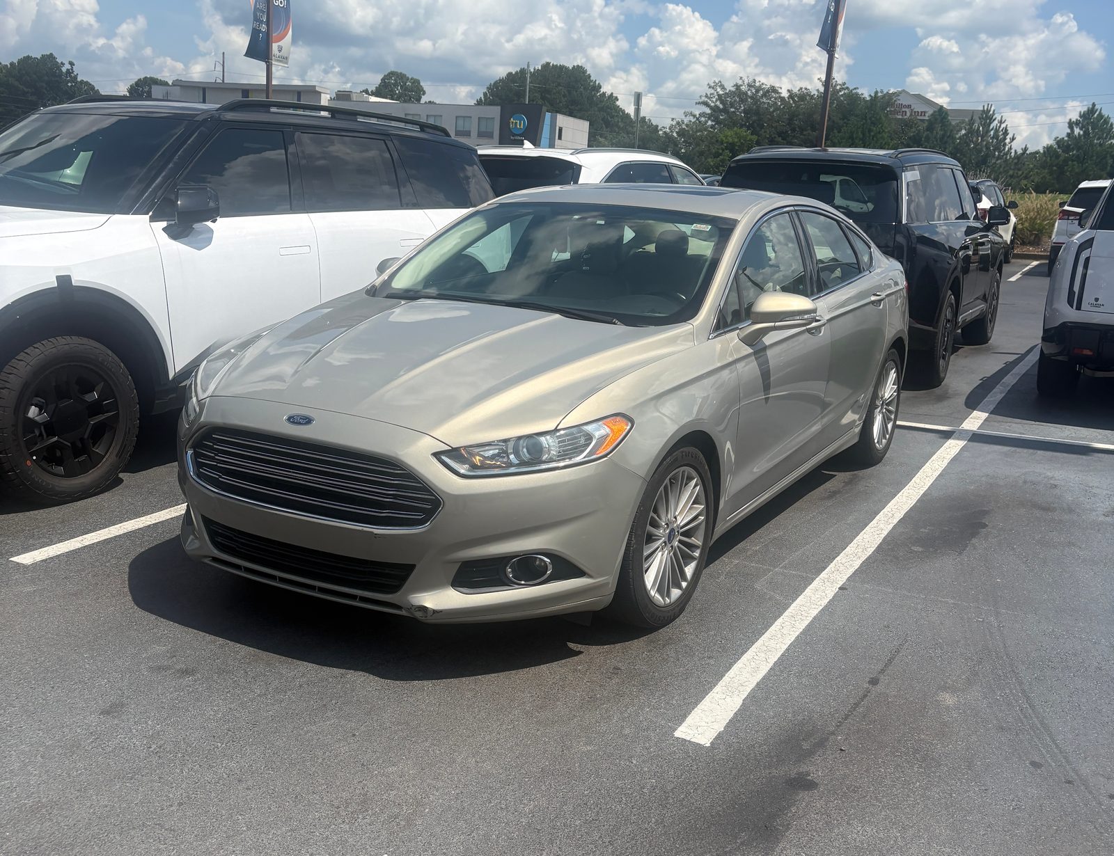 2015 Ford Fusion SE in gold, front three-quarter view